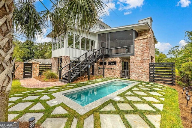 rear view of property featuring a patio area and a sunroom