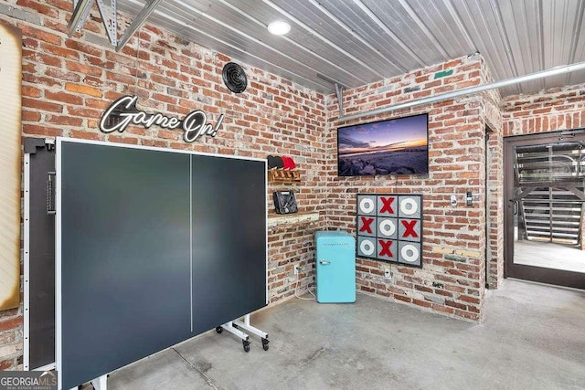 misc room with concrete floors and brick wall