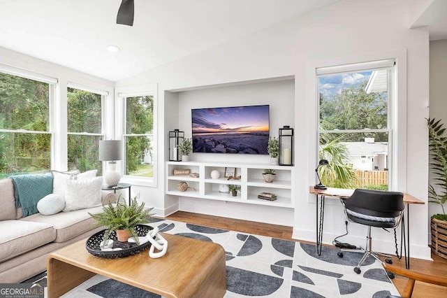 sunroom / solarium featuring lofted ceiling, ceiling fan, and a wealth of natural light