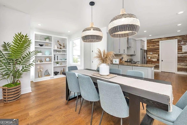 dining area featuring wooden walls and light hardwood / wood-style flooring