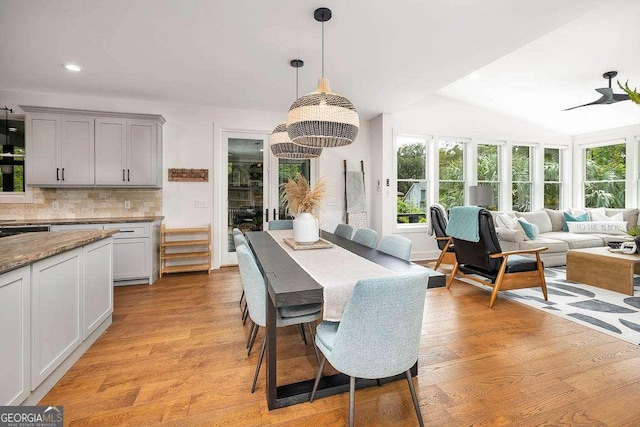 dining area with lofted ceiling, light wood-type flooring, and ceiling fan