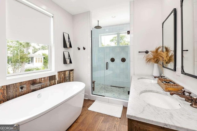 bathroom featuring independent shower and bath, vanity, and wood-type flooring