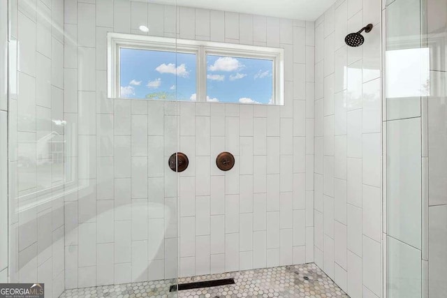 bathroom with tiled shower and a wealth of natural light