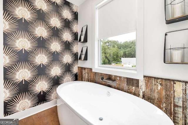 full bathroom featuring a wainscoted wall and a freestanding tub