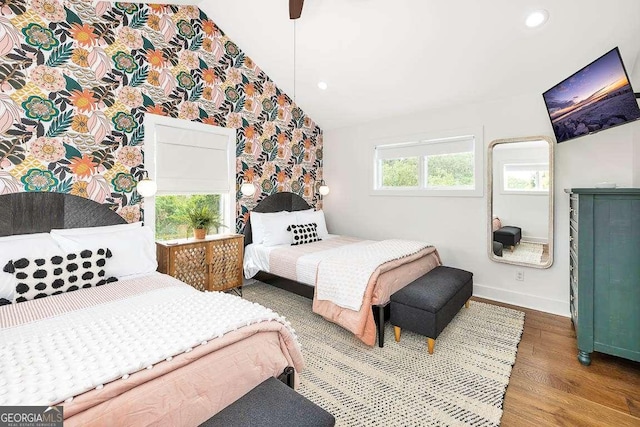 bedroom with ceiling fan, vaulted ceiling, and hardwood / wood-style flooring