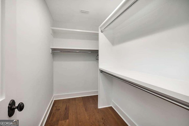 spacious closet with dark wood-style flooring and visible vents