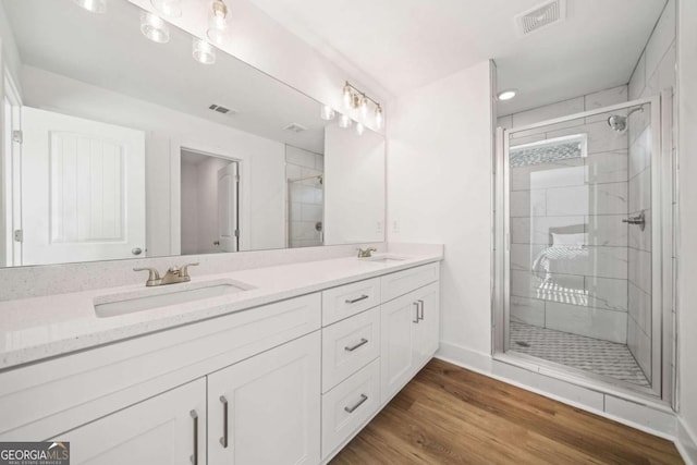 bathroom with an enclosed shower, vanity, and hardwood / wood-style flooring