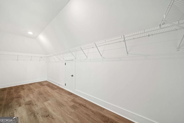 walk in closet featuring hardwood / wood-style floors and lofted ceiling