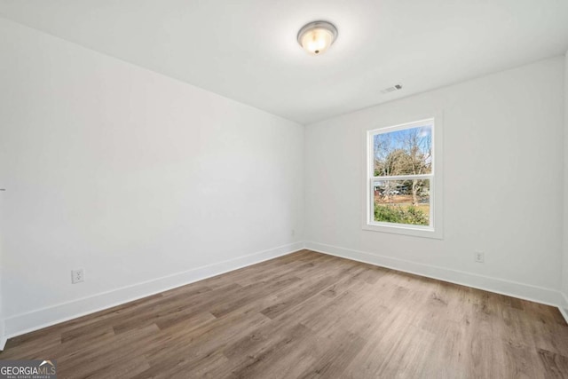 unfurnished room featuring hardwood / wood-style flooring