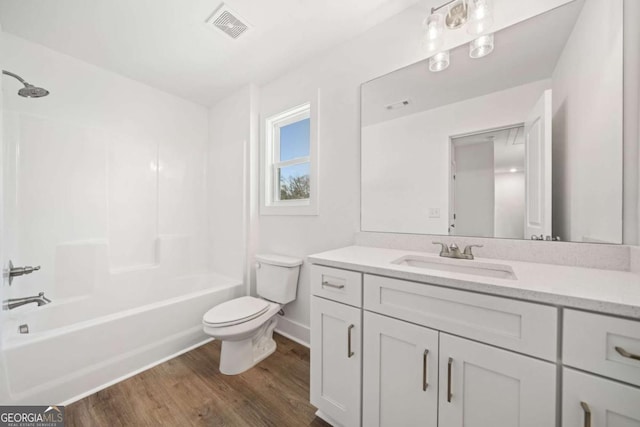 full bathroom featuring bathing tub / shower combination, toilet, vanity, and hardwood / wood-style flooring