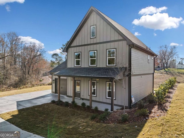 view of front of home with a porch, a front lawn, and a garage