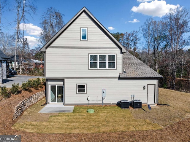 rear view of house featuring a patio, central AC, and a yard