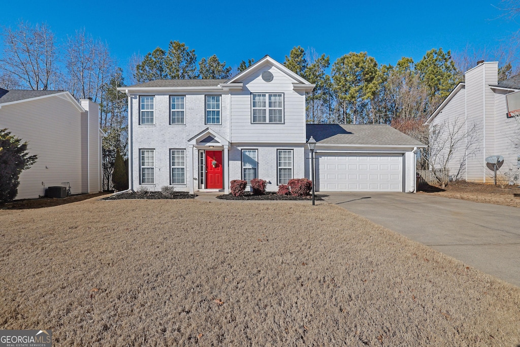 view of front of home featuring a garage, a front yard, and cooling unit