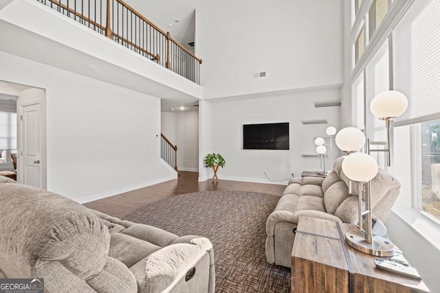 living room featuring a high ceiling and dark wood-type flooring