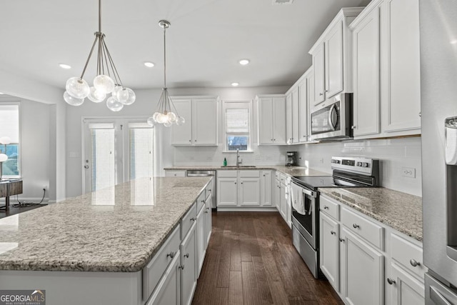 kitchen featuring stainless steel appliances, a kitchen island, and white cabinets