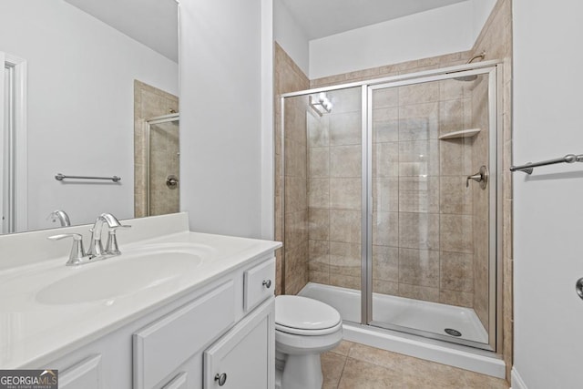 bathroom featuring a shower with door, tile patterned flooring, vanity, and toilet