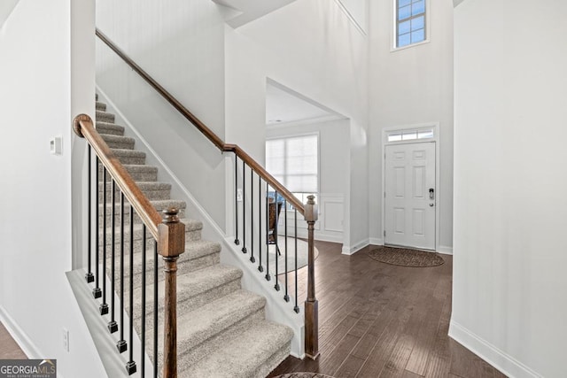 entrance foyer featuring a towering ceiling and dark hardwood / wood-style floors