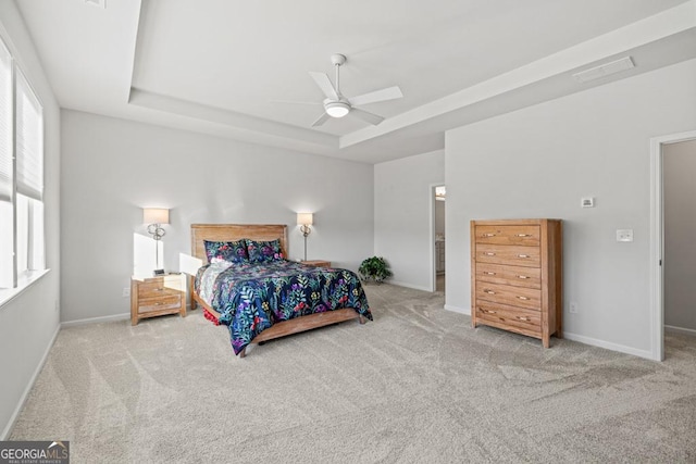 bedroom with ceiling fan, a raised ceiling, and carpet floors