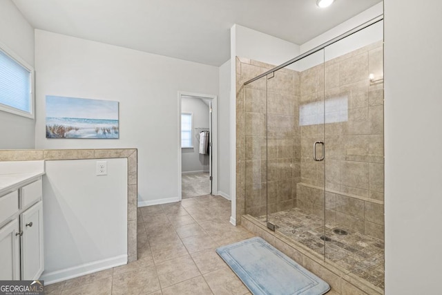 bathroom featuring walk in shower, vanity, and tile patterned floors