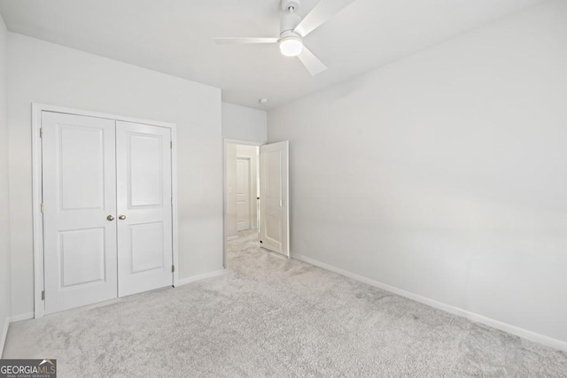 unfurnished bedroom featuring a closet, ceiling fan, and light colored carpet