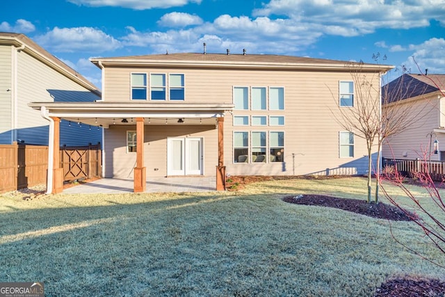 back of property with a lawn and a patio