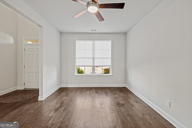 spare room with dark wood-type flooring and ceiling fan