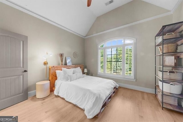 bedroom featuring ceiling fan, ornamental molding, lofted ceiling, and hardwood / wood-style flooring