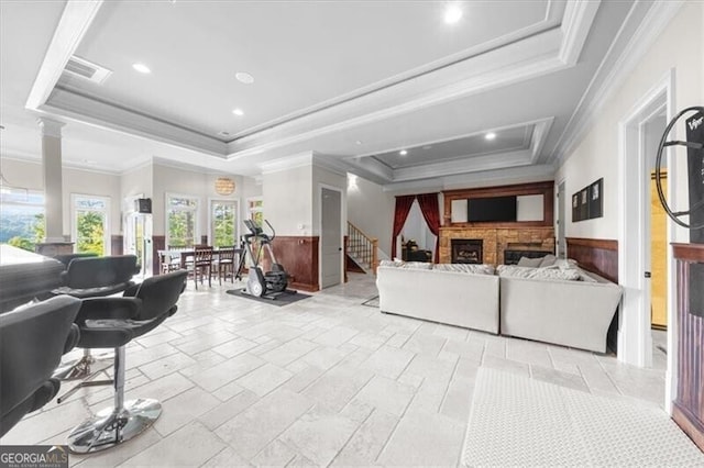 living room with a raised ceiling and ornamental molding