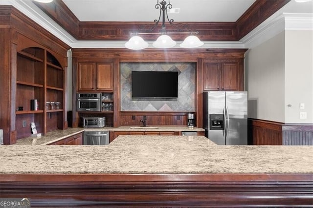 kitchen featuring appliances with stainless steel finishes, crown molding, pendant lighting, light stone counters, and sink