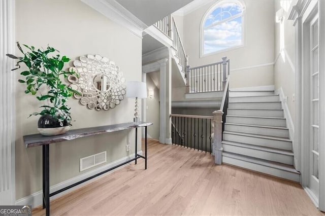 staircase featuring hardwood / wood-style floors and ornamental molding