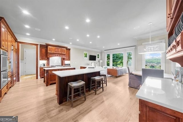 kitchen with ornamental molding, a breakfast bar area, and a spacious island