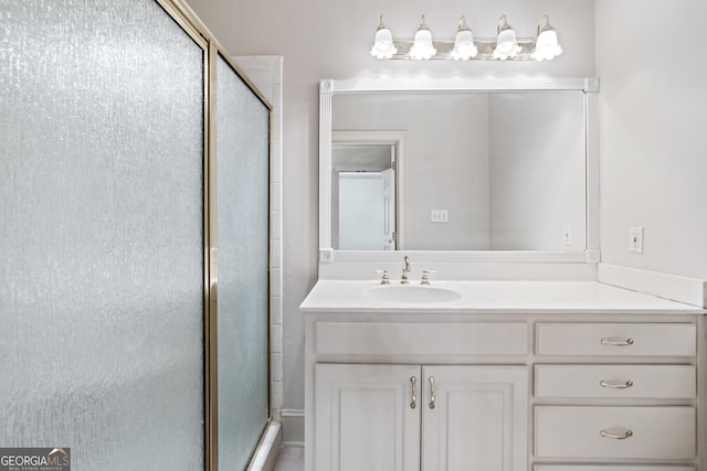 bathroom with a shower with shower door and vanity