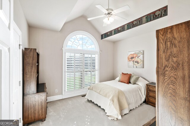 bedroom featuring ceiling fan, light colored carpet, and vaulted ceiling