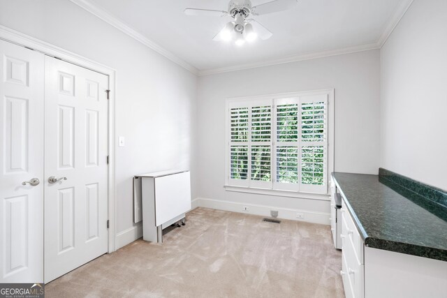 interior space with ceiling fan, a closet, light carpet, and ornamental molding