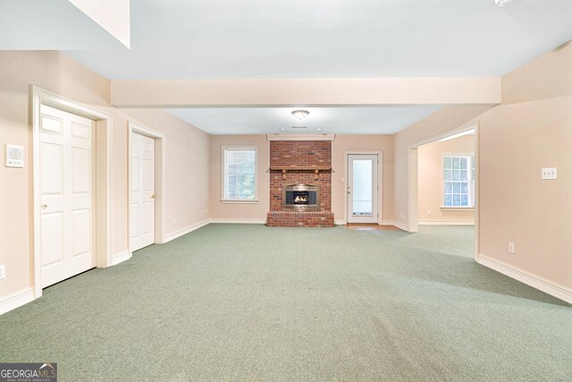 unfurnished living room featuring carpet flooring and a fireplace