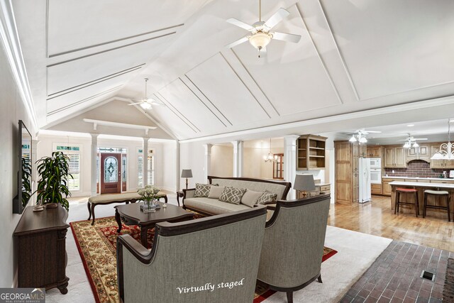 living room with lofted ceiling and ornate columns