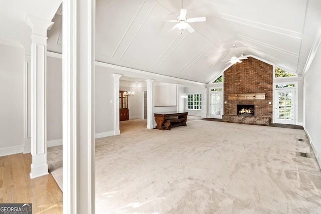 unfurnished living room with lofted ceiling, ceiling fan, a brick fireplace, and plenty of natural light