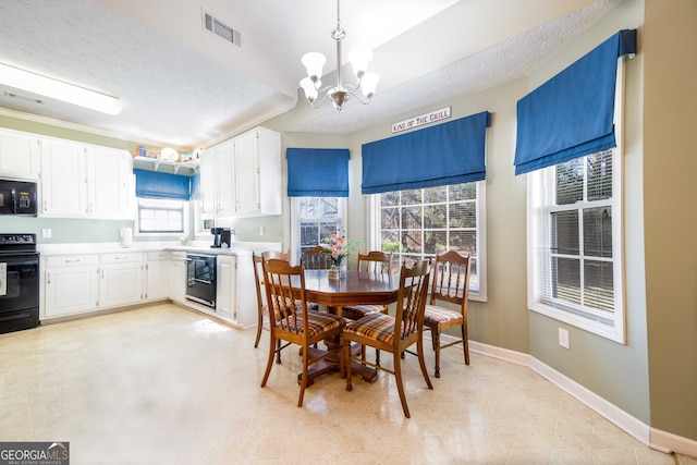 dining space with a textured ceiling and a chandelier