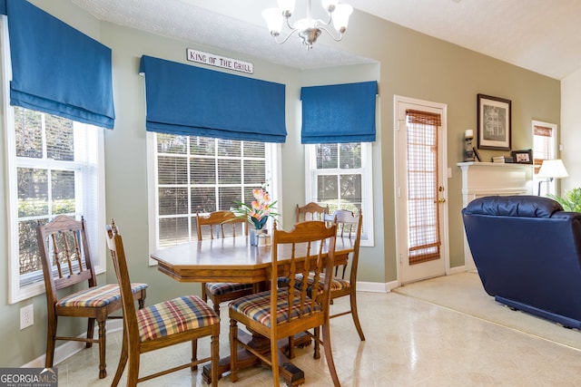 dining space with an inviting chandelier and a textured ceiling