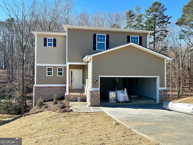 view of front of house featuring driveway, a garage, and brick siding