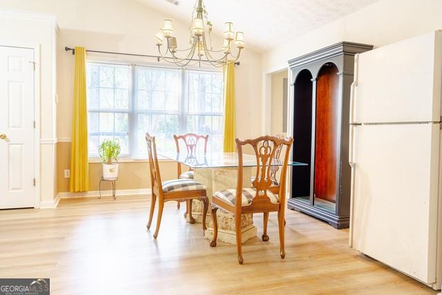 dining area with a notable chandelier and light hardwood / wood-style floors