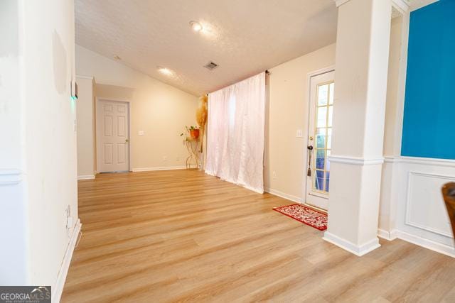 interior space with lofted ceiling and light wood-type flooring