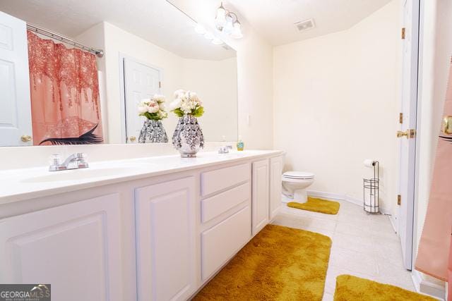 bathroom featuring tile patterned floors, vanity, and toilet