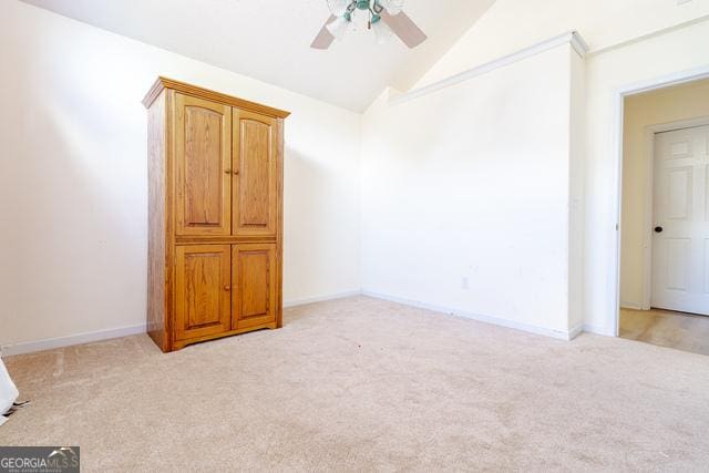 carpeted empty room featuring ceiling fan and vaulted ceiling