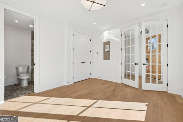 unfurnished room with wood-type flooring, french doors, and electric panel