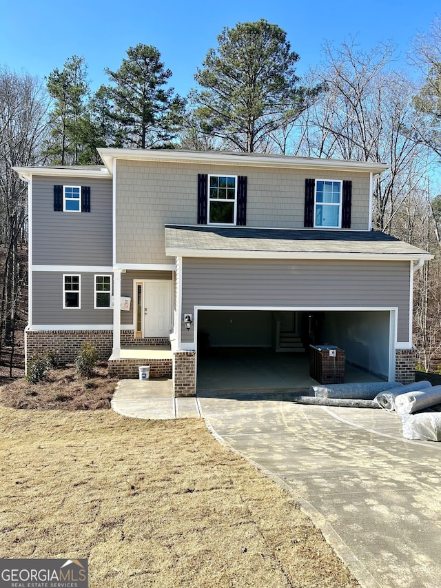 view of front of property featuring driveway, an attached garage, and brick siding