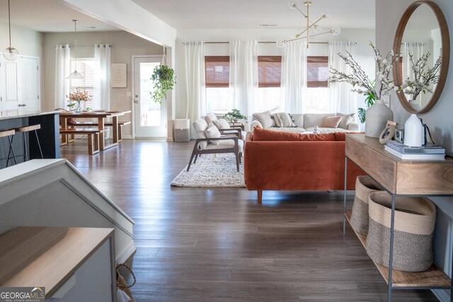 living room featuring hardwood / wood-style floors, an inviting chandelier, and a large fireplace