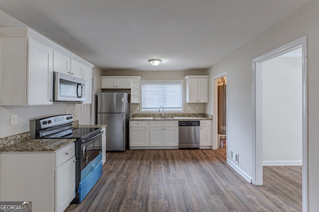 kitchen with sink, white cabinetry, stone countertops, dark hardwood / wood-style floors, and appliances with stainless steel finishes