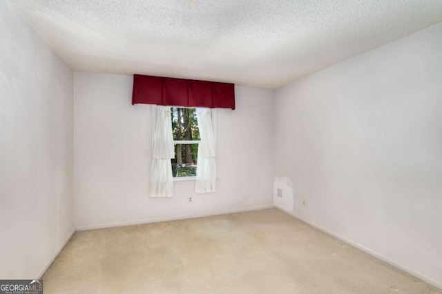 carpeted empty room with a textured ceiling