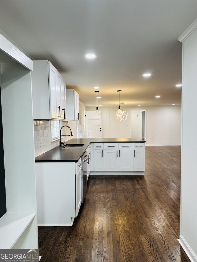 kitchen featuring sink, hanging light fixtures, white cabinetry, and tasteful backsplash